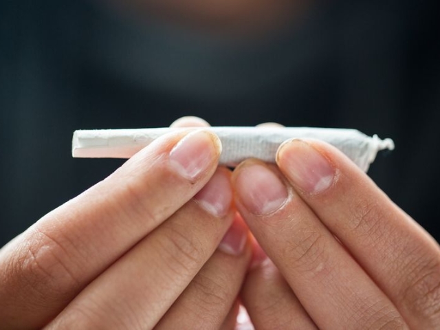 two hands are shown holding a joint