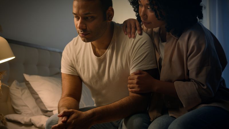 Woman supporting man as he struggles with emotions