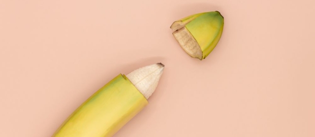 Banana with tip separated on peach-colored background