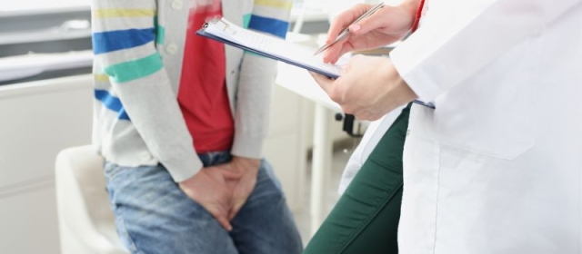 Man with hand over jeans and doctor in frame