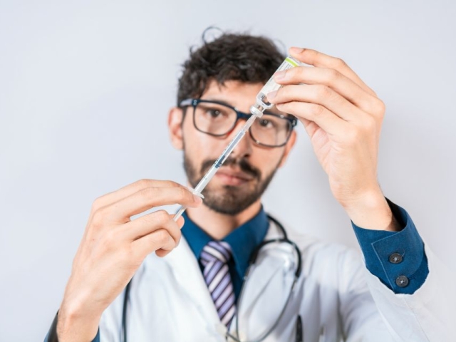 Man doctor drawing injection