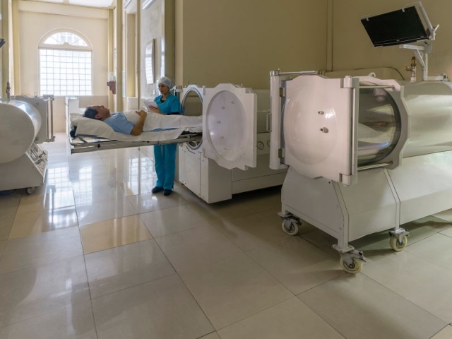 Man laying on hyperbaric chamber bed