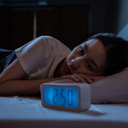 woman staring at clock in the early morning