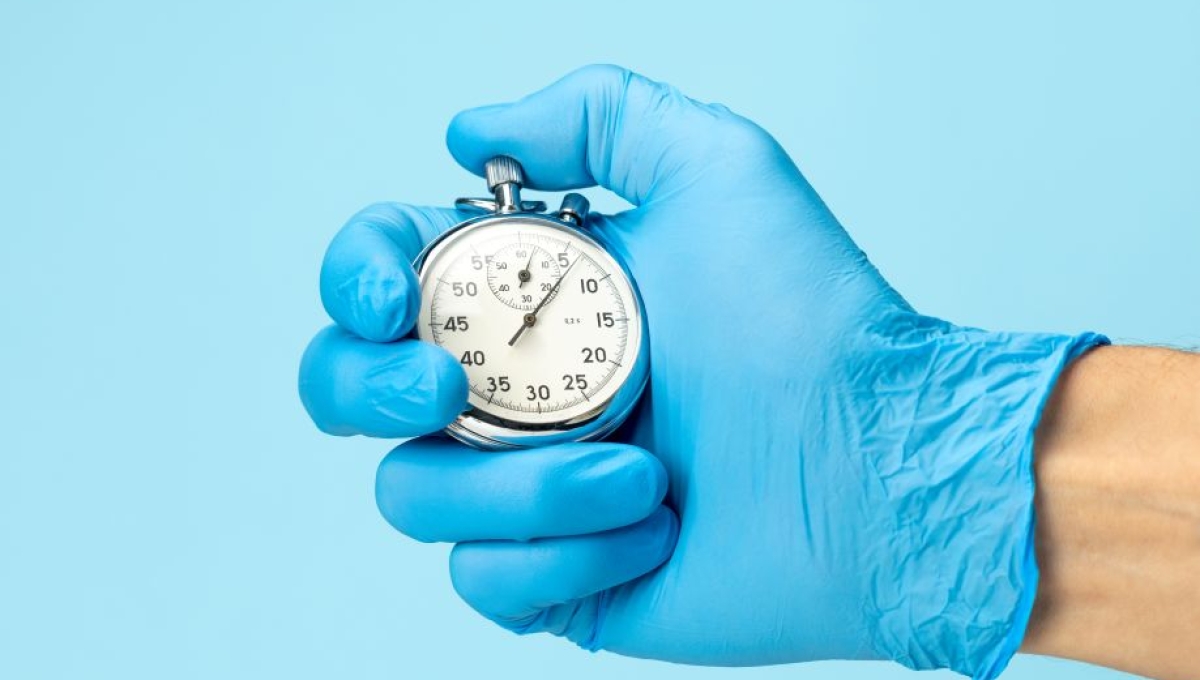 Gloved hand holding stopwatch