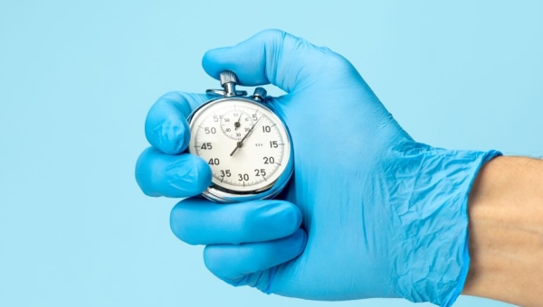 Gloved hand holding stopwatch