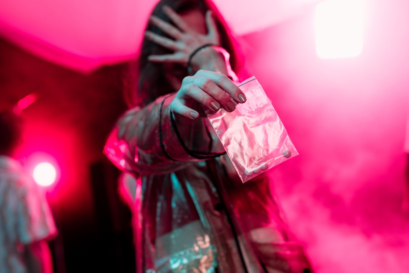 woman holding dime bag in pink room