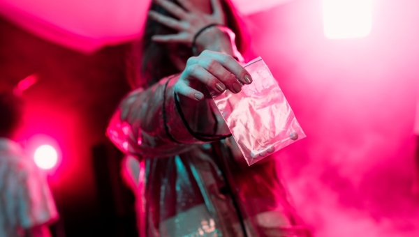 woman holding dime bag in pink room
