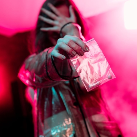 woman holding dime bag in pink room