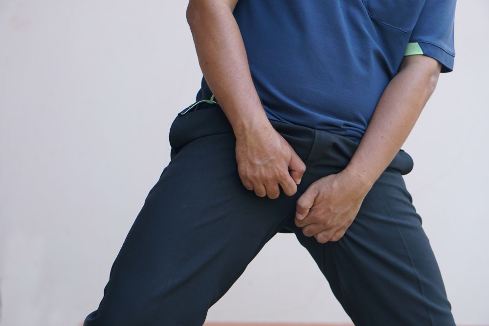 man holding crotch in pain