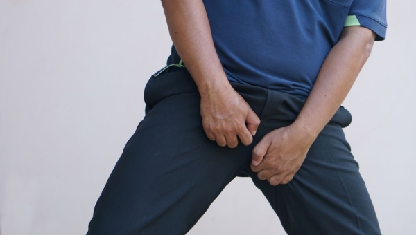 man holding crotch in pain