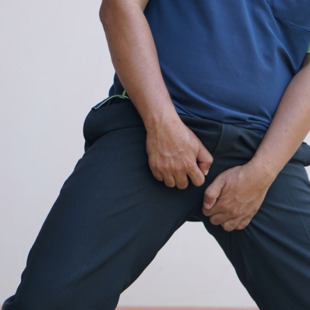 man holding crotch in pain