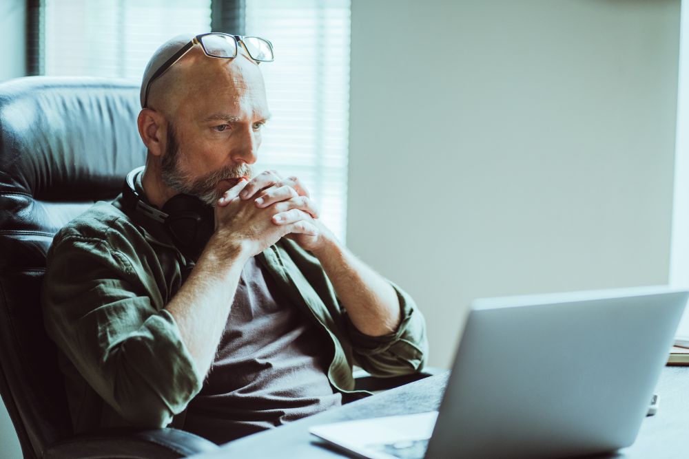 man looking thoughtfully at computer