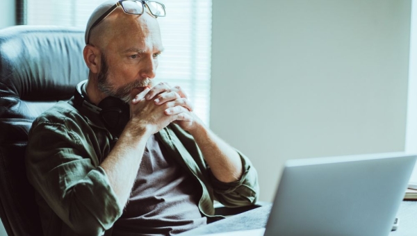 man looking thoughtfully at computer